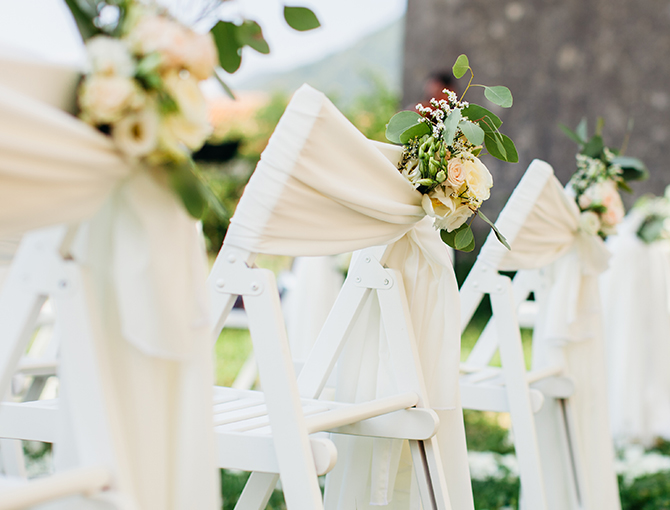white chairs with ivory sashes and flowers